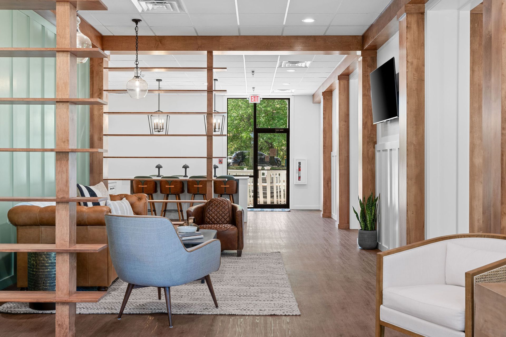 A living room with a couch , chairs , and a television.