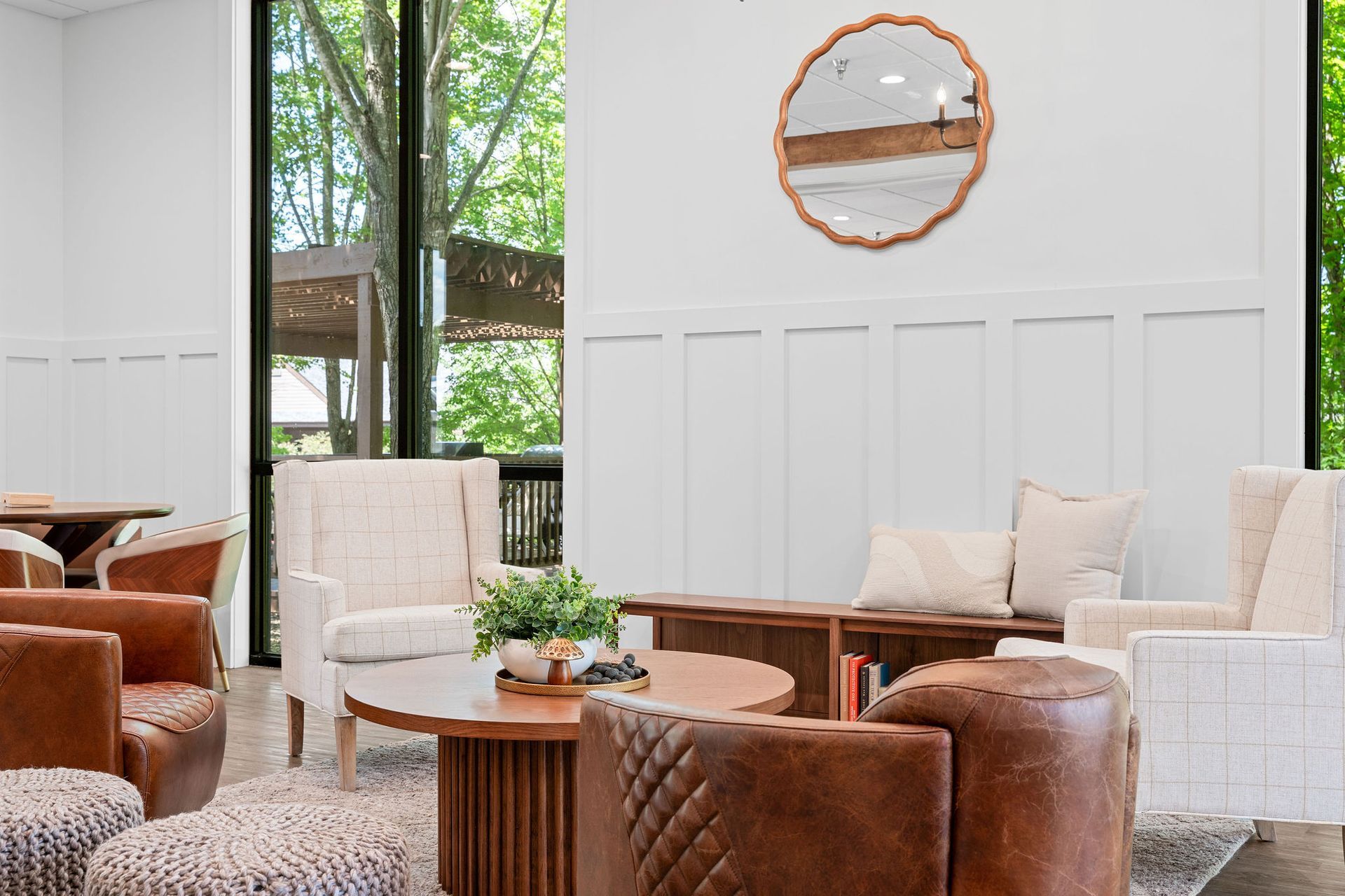 A living room filled with furniture and a mirror on the wall.