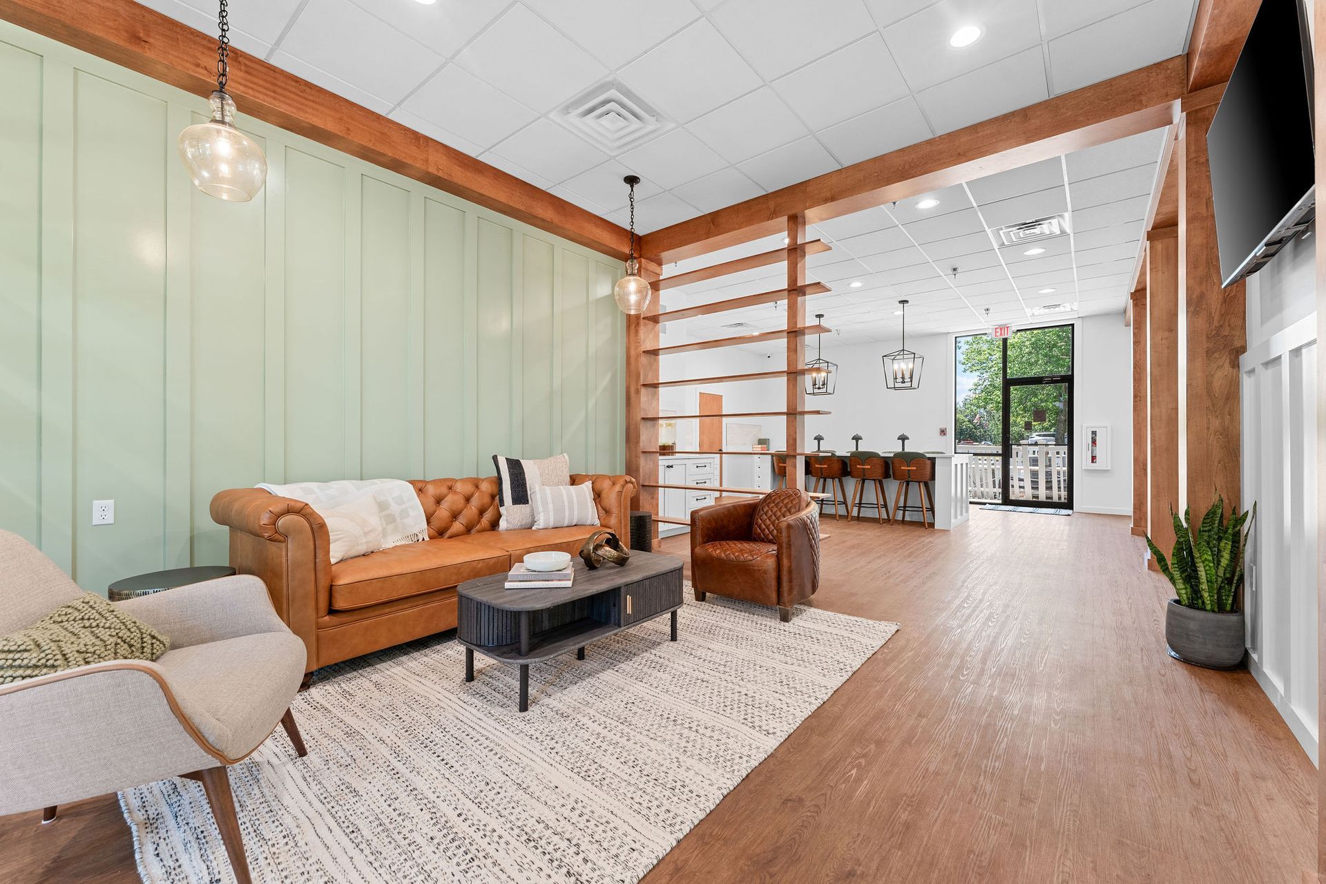 A living room with a couch , chair , coffee table and television.