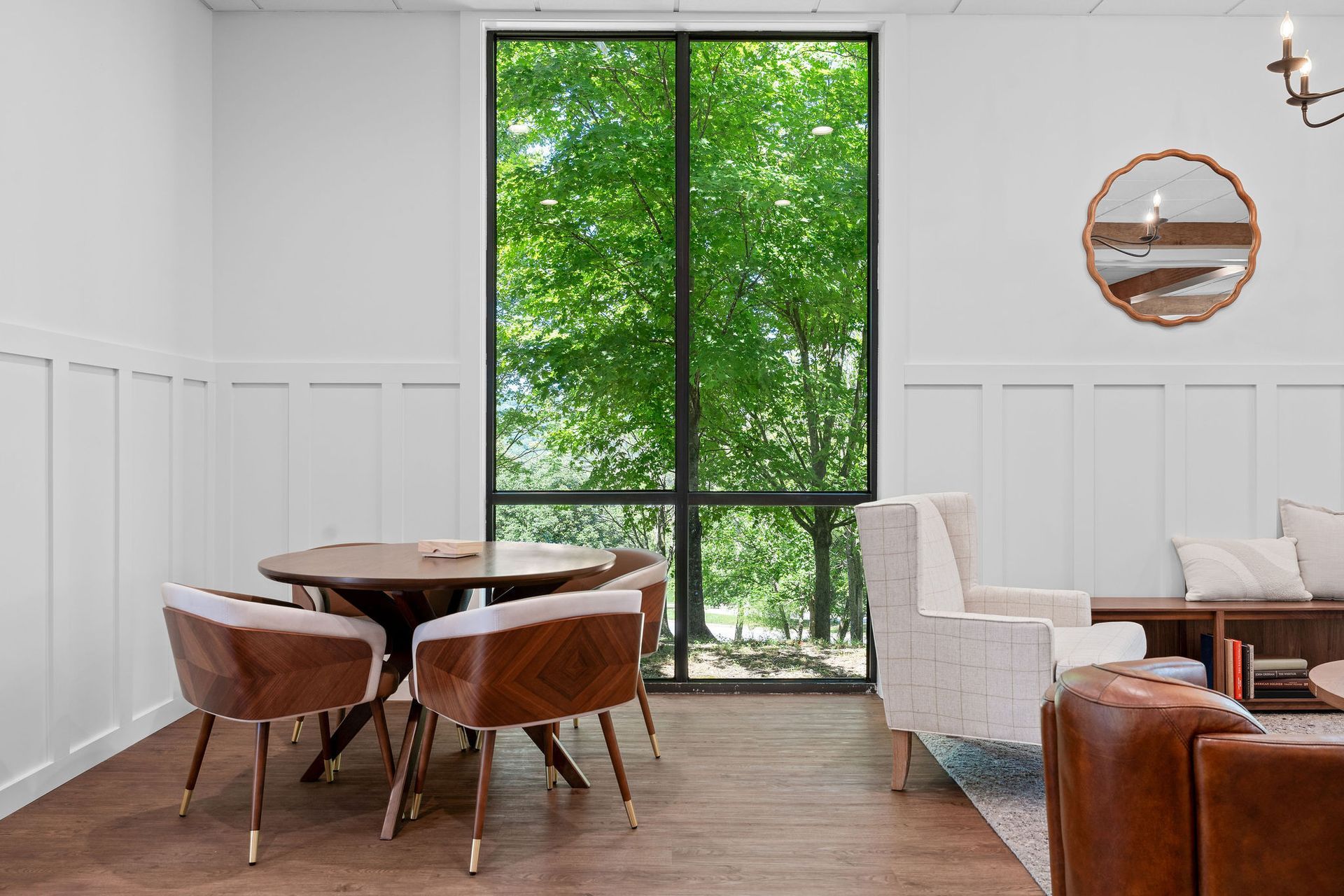 A living room with a table and chairs and a large window.