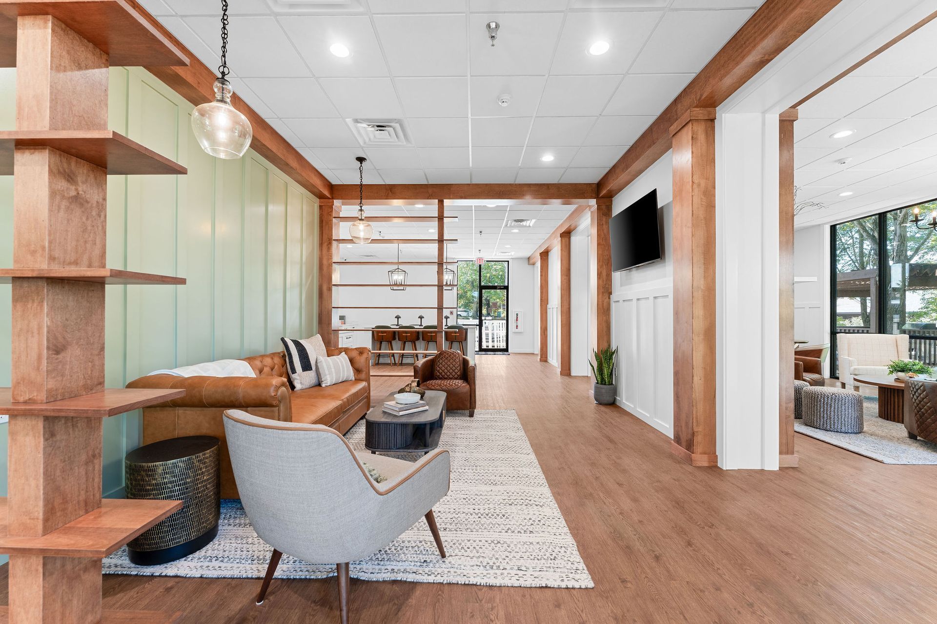 A living room with a couch , chairs , tables and a television.