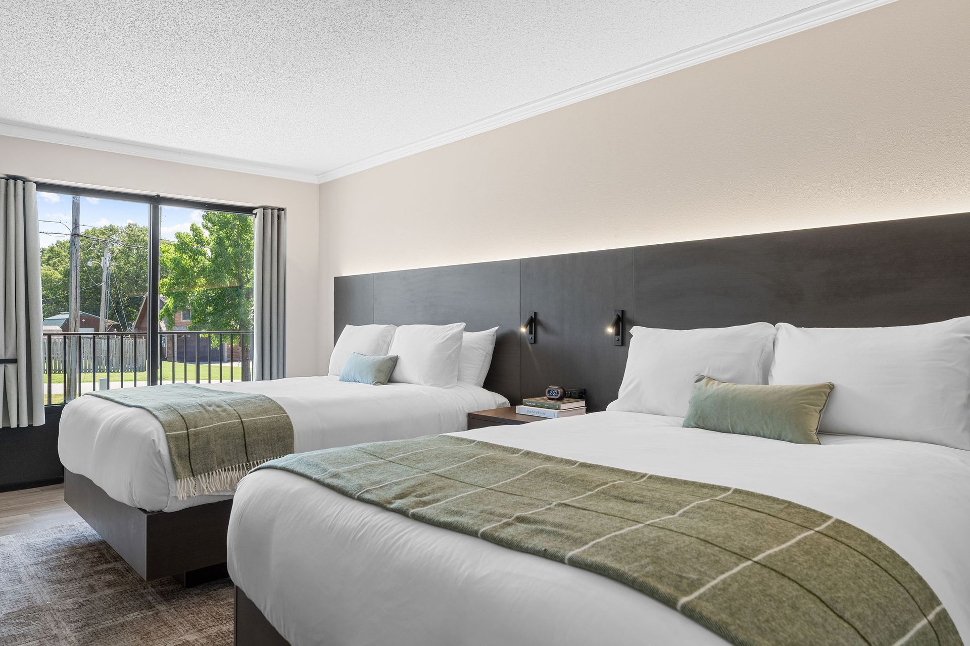 A hotel room with two beds and a large window.