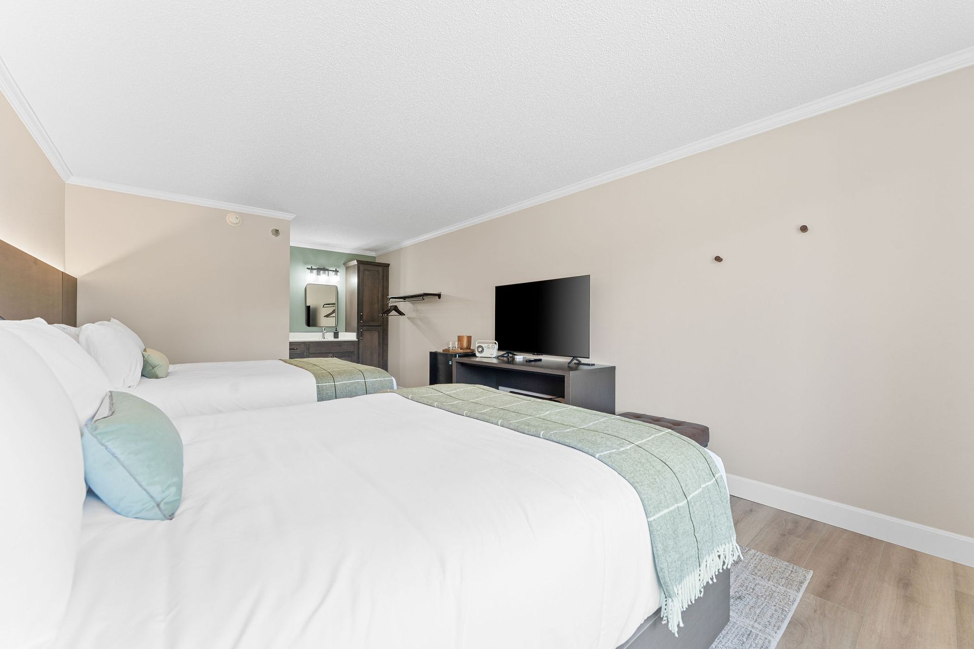 A hotel room with two beds and a flat screen tv.