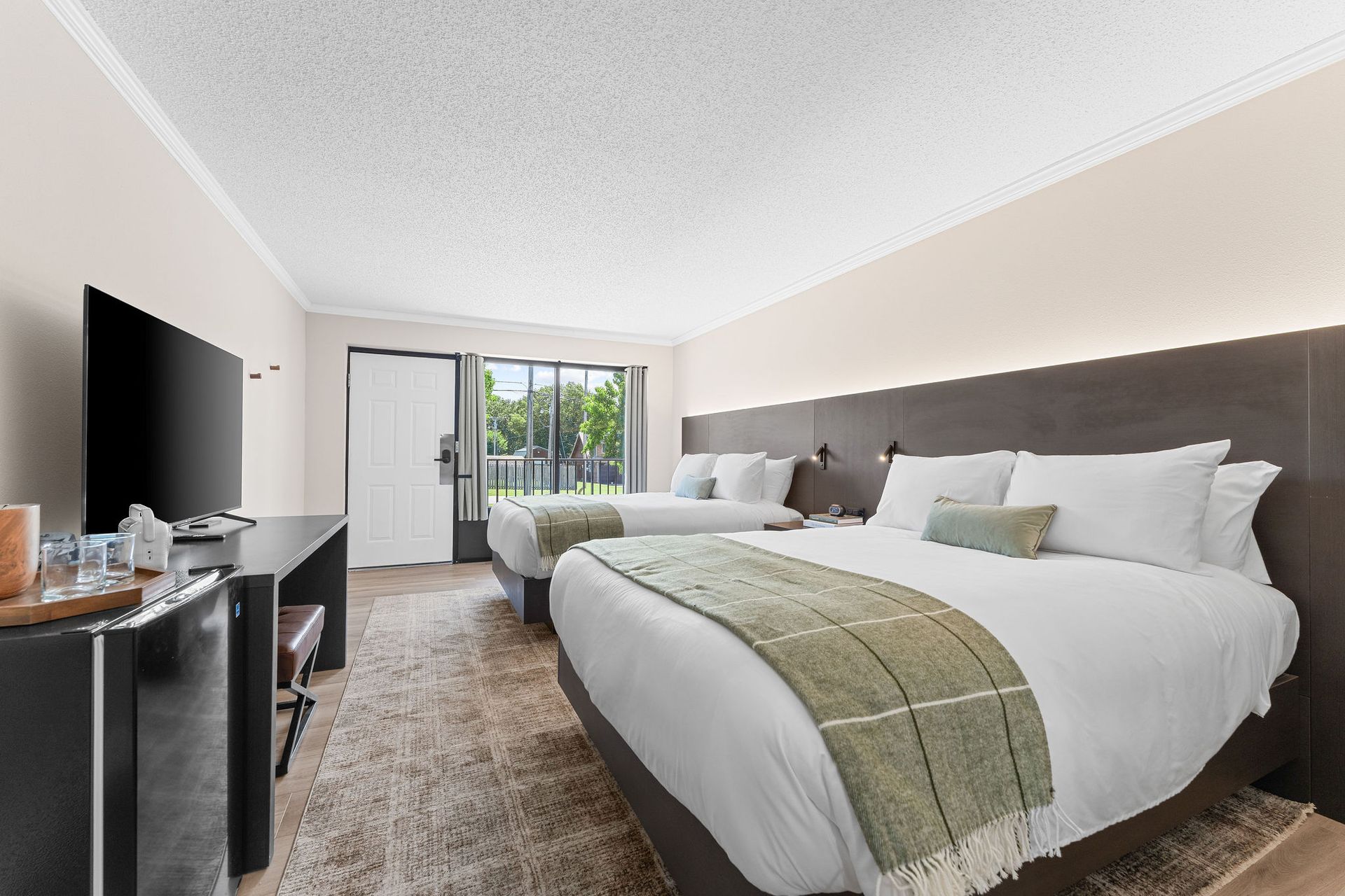 A hotel room with two beds and a flat screen tv.