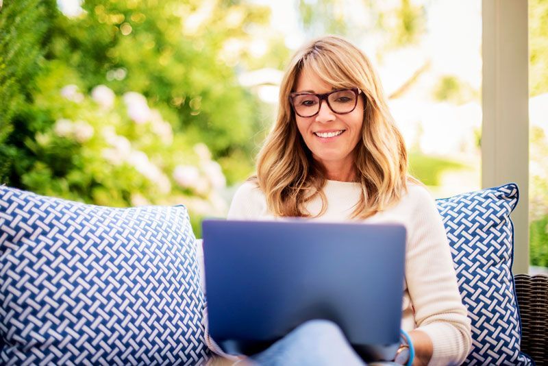 Counselor working on her laptop from a sunny patio