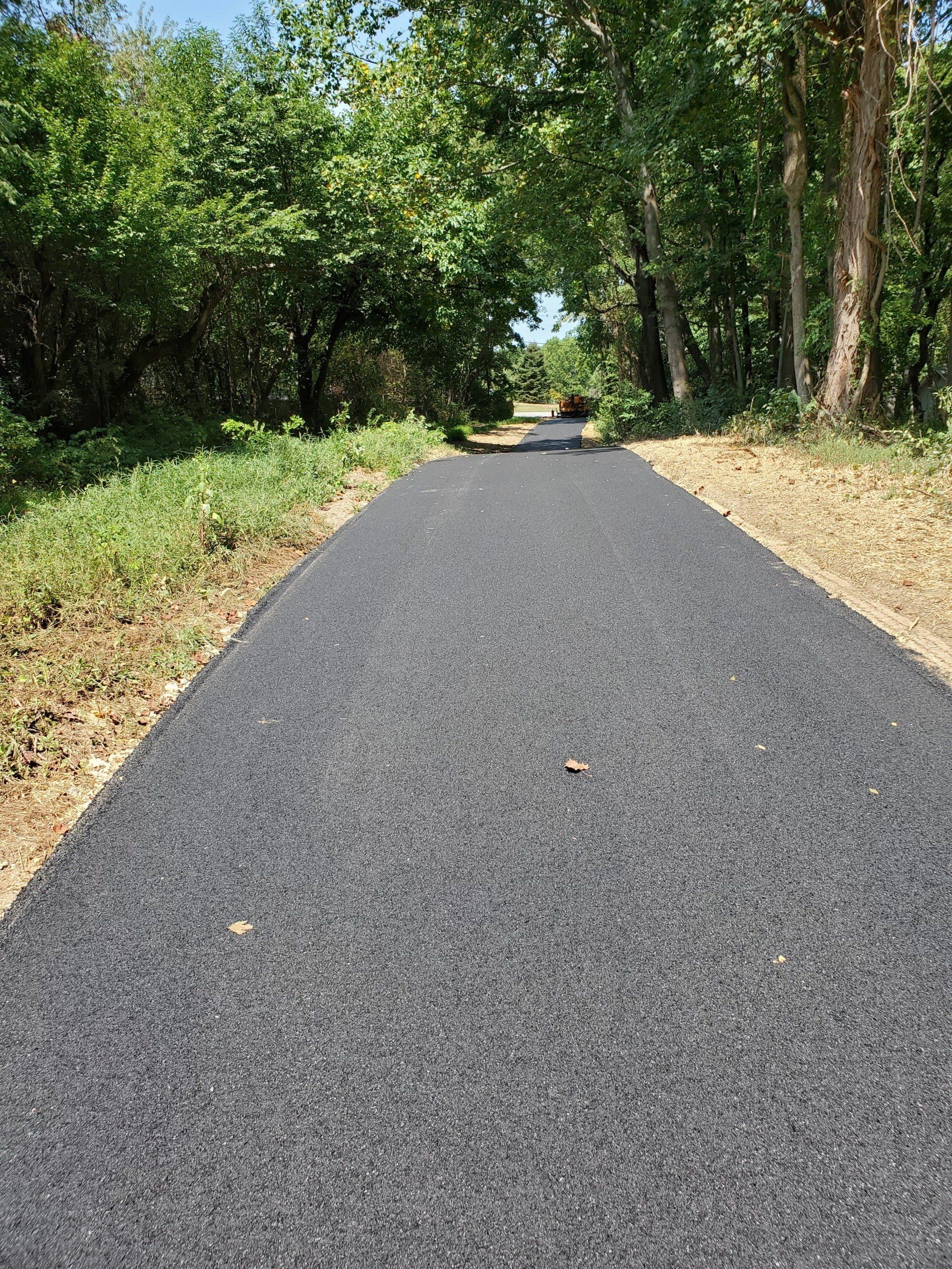 A long road with trees on both sides, creating a scenic pathway