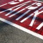 A road with a red mark and the word 'parking,' indicating a designated parking area or zone