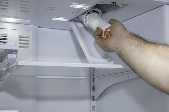 a man is opening the door of a refrigerator