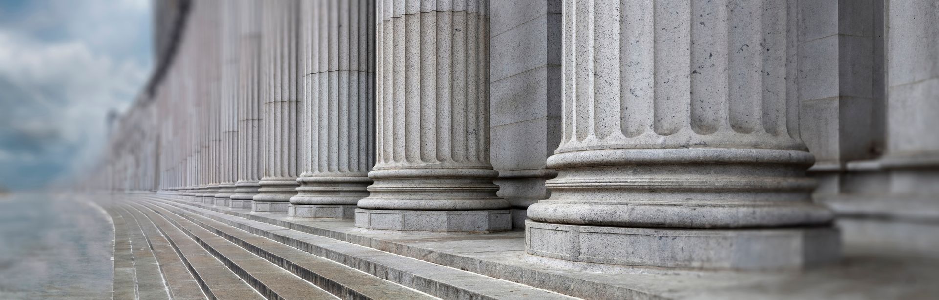 A row of columns on a building with stairs leading up to them.