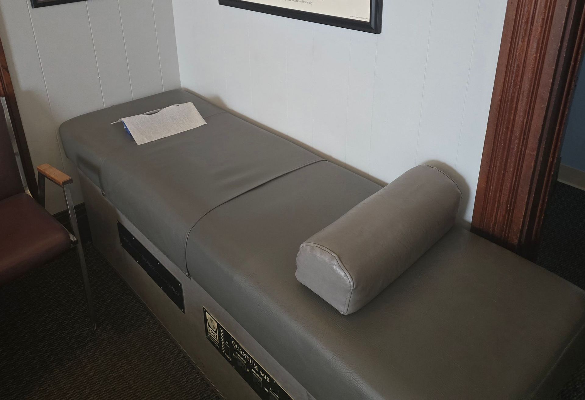 A gray massage table with a pillow on it