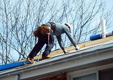 Un homme travaille sur le toit d'une maison.