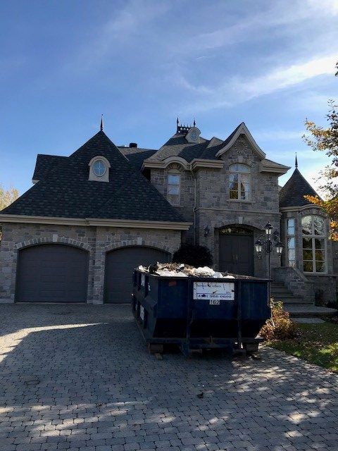 Une grande maison avec une benne devant