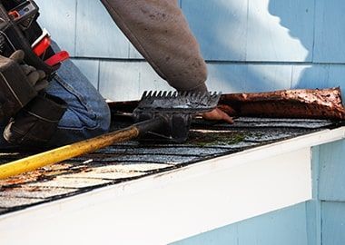 Un homme travaille sur un toit avec un outil.