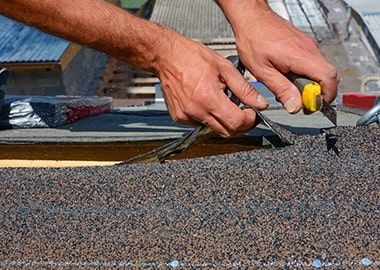 Un homme travaille sur un toit avec une paire de pinces.