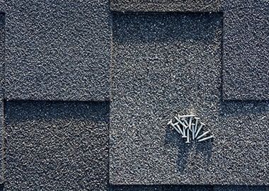 Un gros plan d'un toit avec des clous qui en sortent.