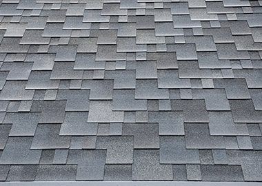 Un gros plan d'un toit avec un motif de tuiles carrées.