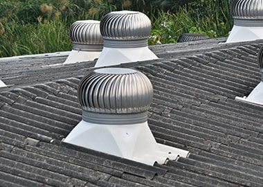 Une rangée de bouches d'aération sur le toit d'un bâtiment.