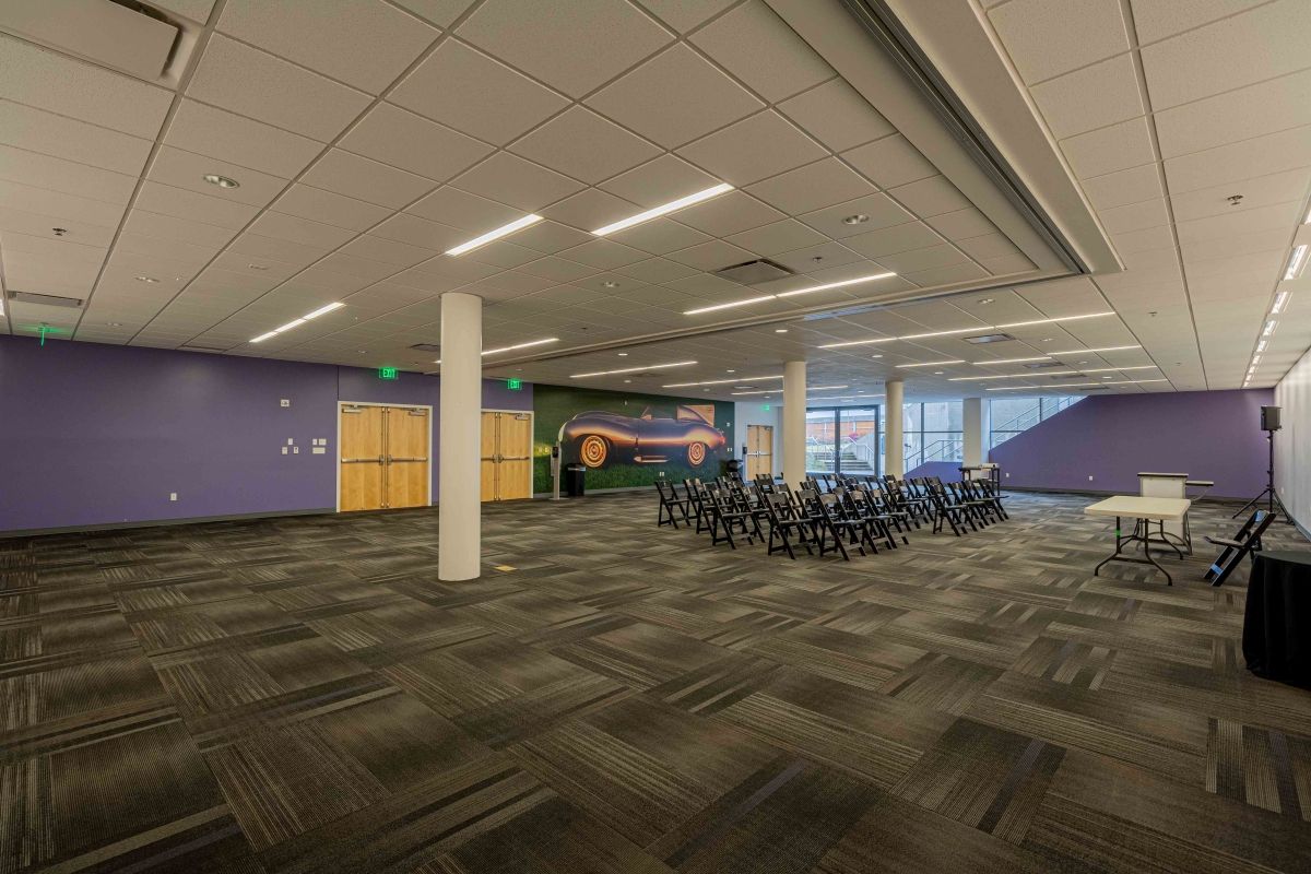 A large empty room with tables and chairs in it.