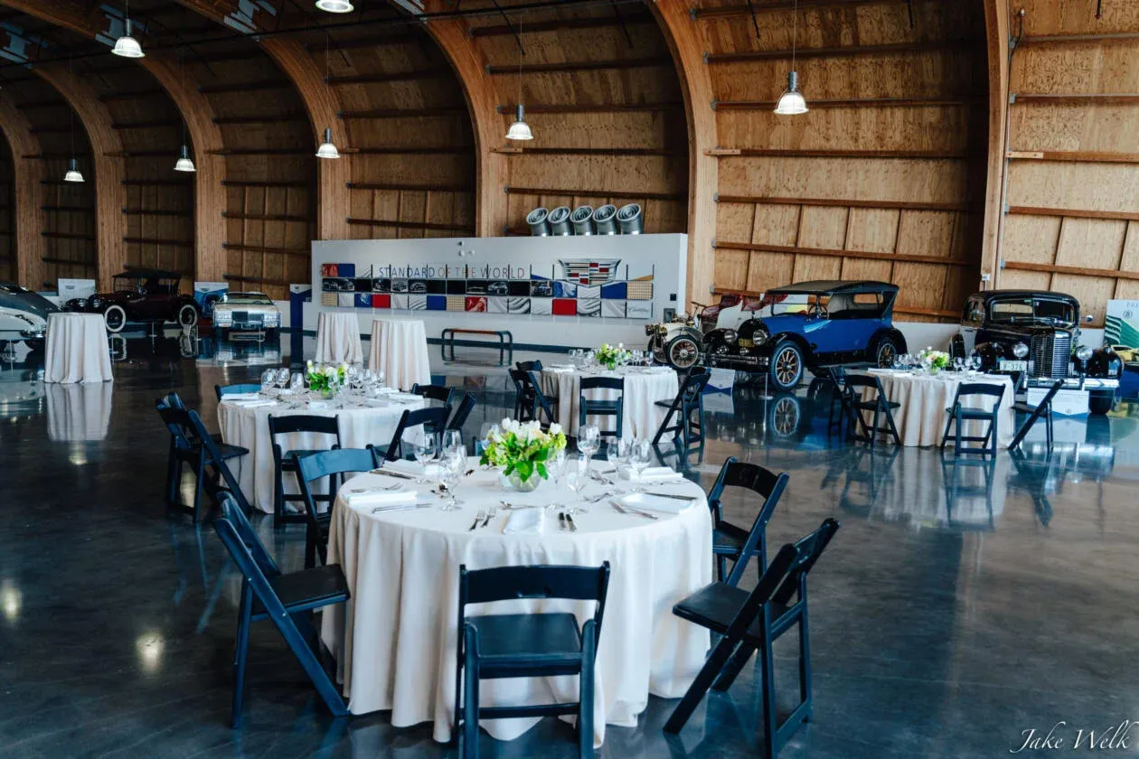 A large room with tables and chairs set up for a wedding reception.