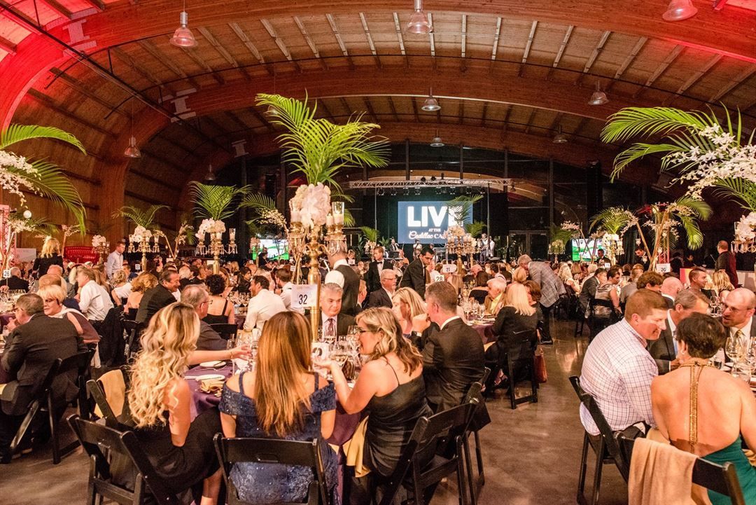 A large group of people are sitting at tables in a large room.