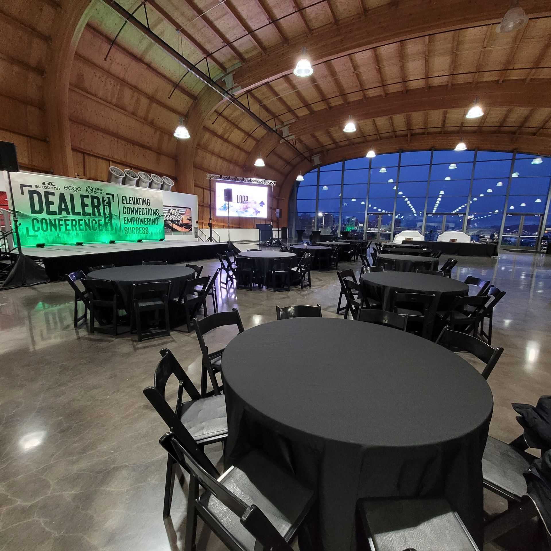 A large room with tables and chairs and a sign that says dealers competing