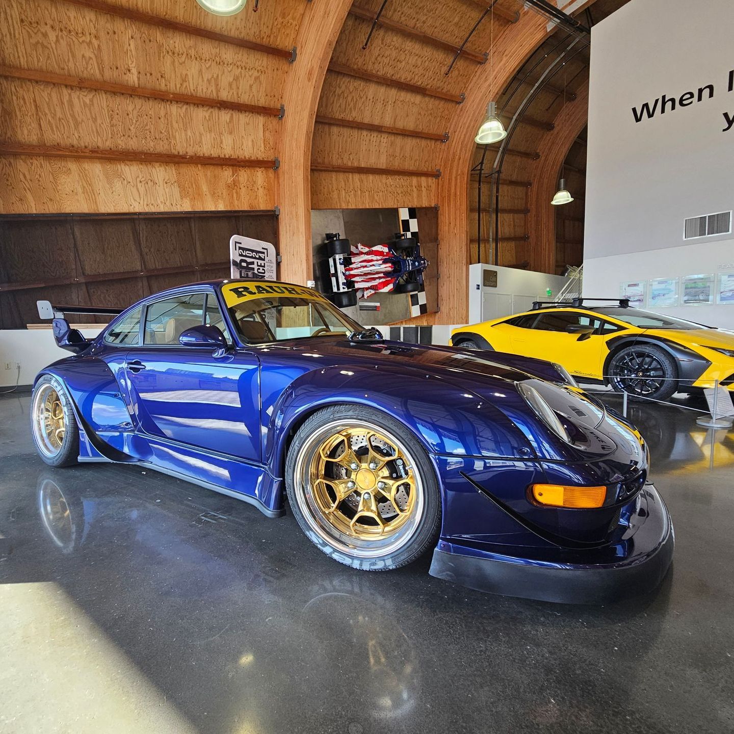 A blue sports car is parked next to a yellow sports car
