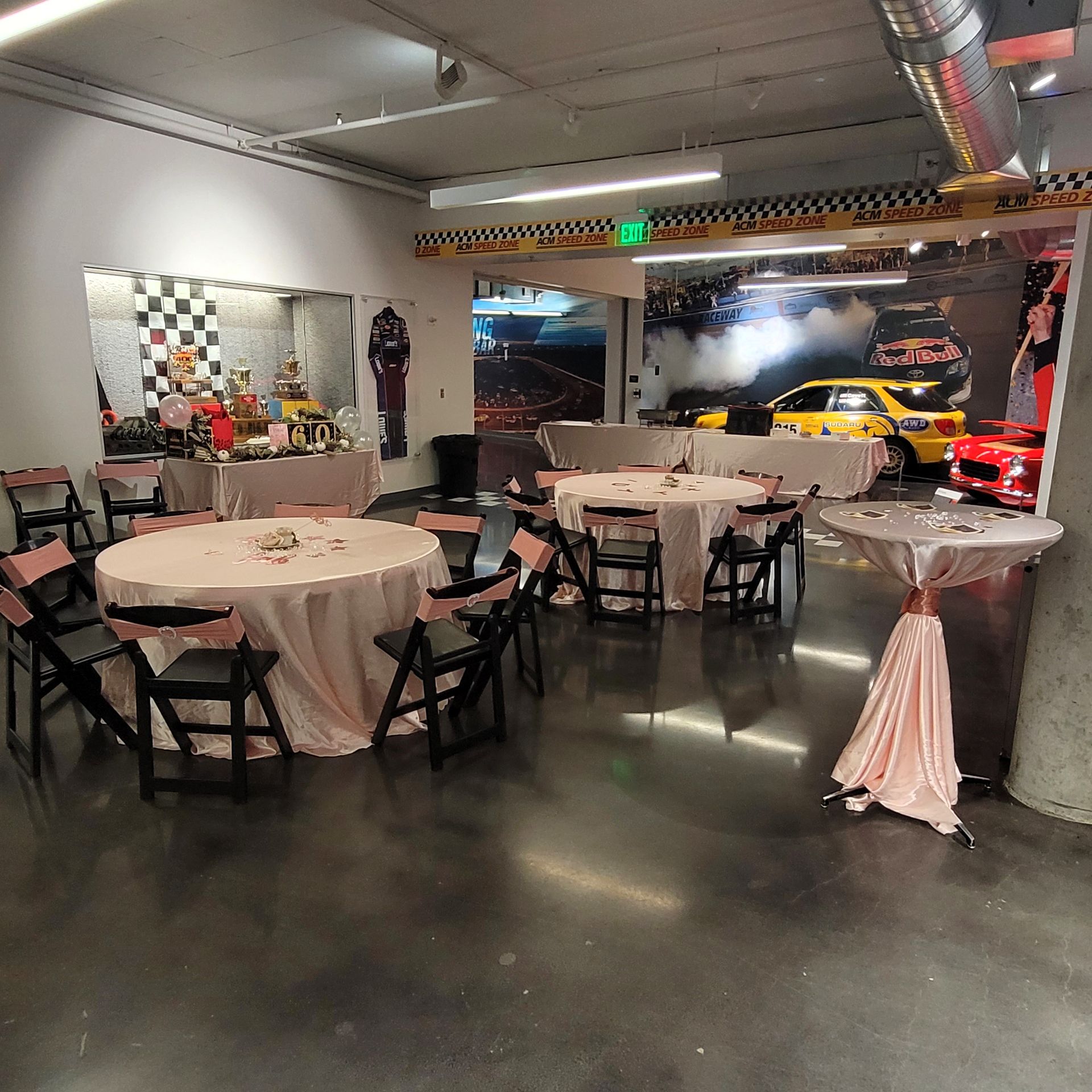 A room with tables and chairs and a yellow car in the background