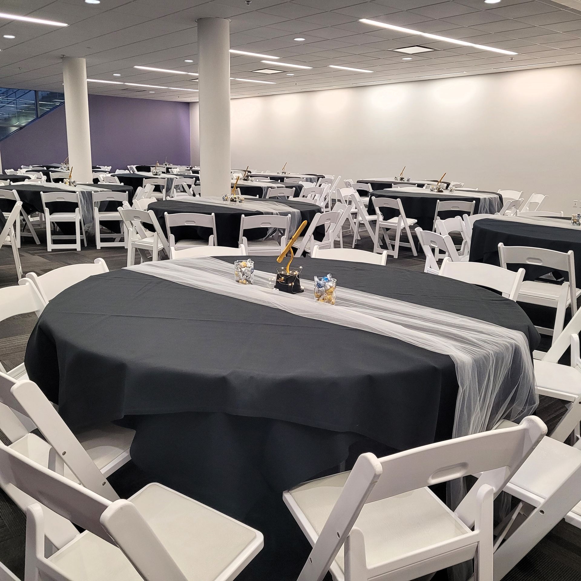 A large room with tables and chairs set up for a party