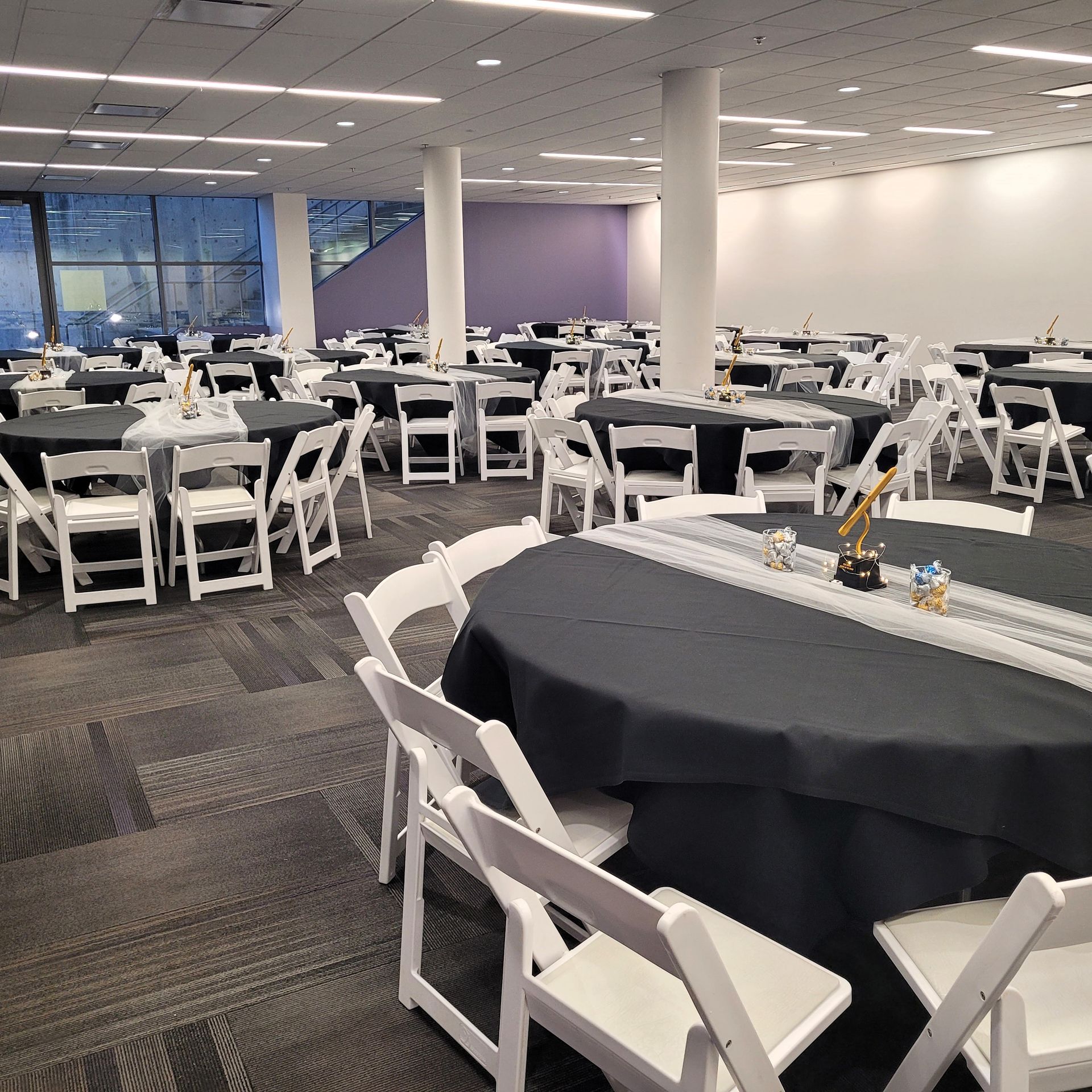 A large room with tables and chairs set up for a party