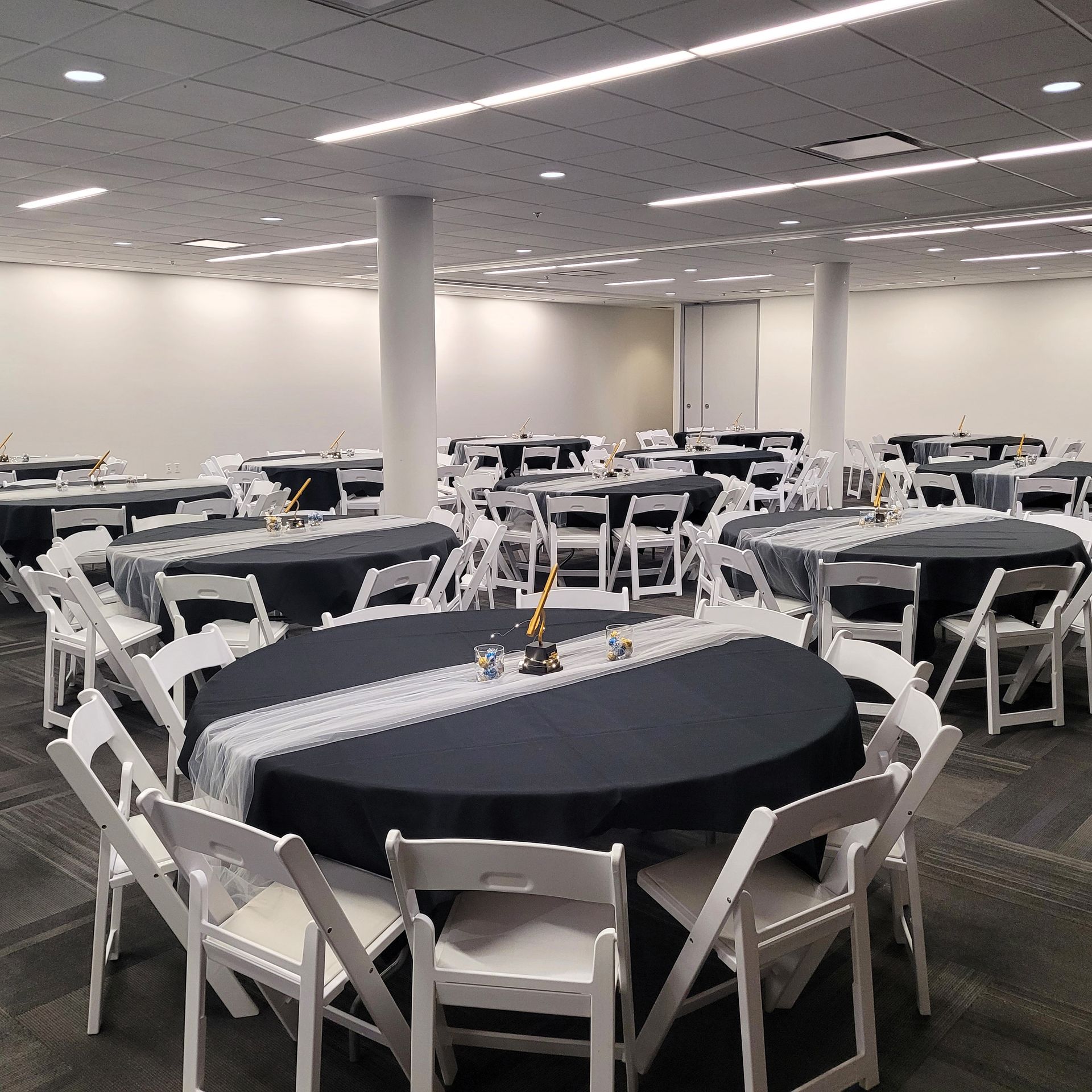 A large room with tables and chairs set up for a party