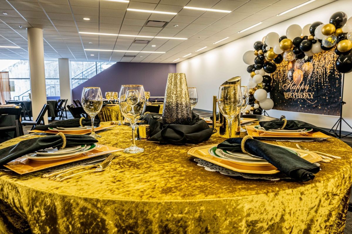 A table set for a party with plates , glasses , and napkins on it.
