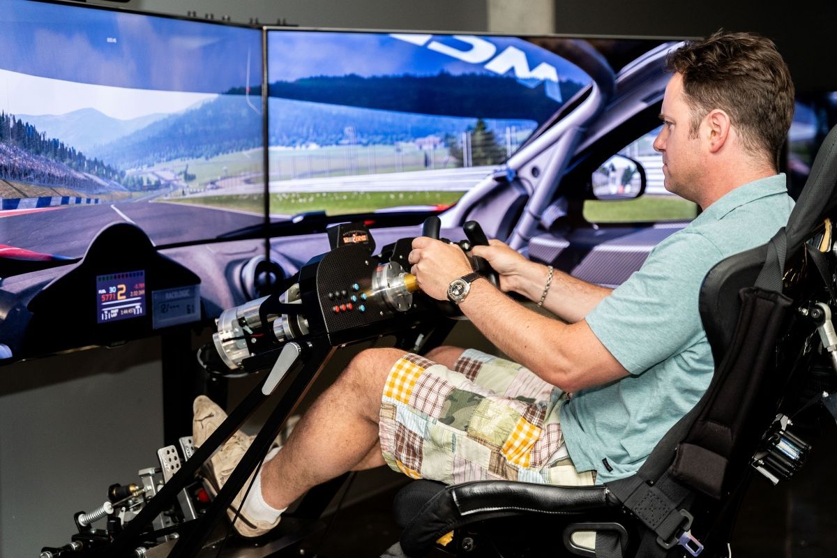 A man is sitting in a simulator playing a video game.