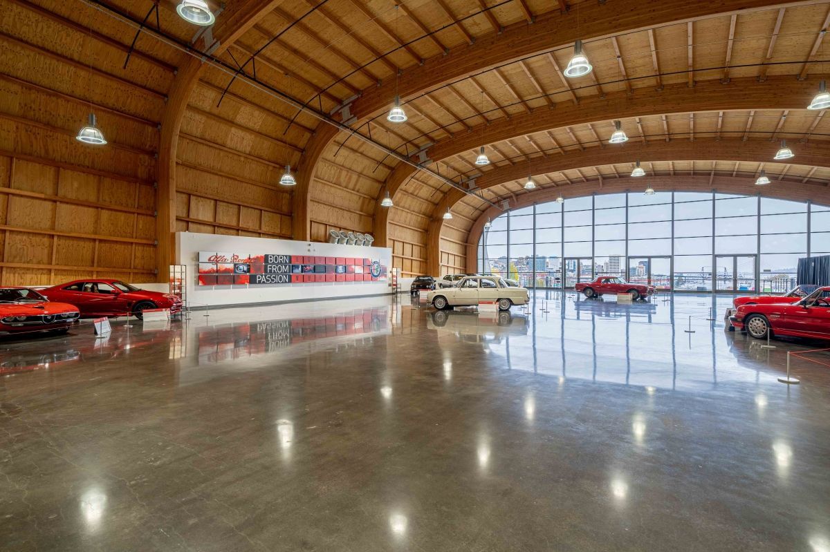 A large room with a lot of cars parked in it.