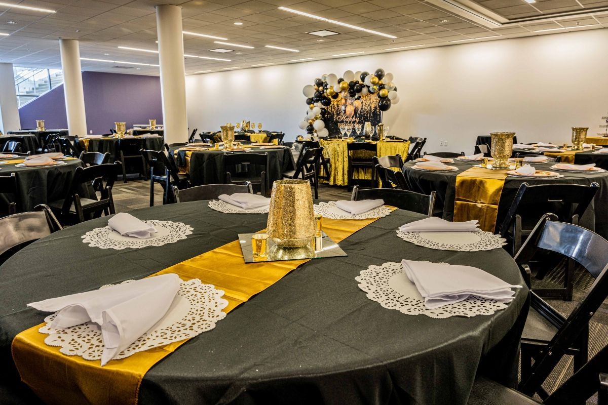 A large room with tables and chairs set up for a party.