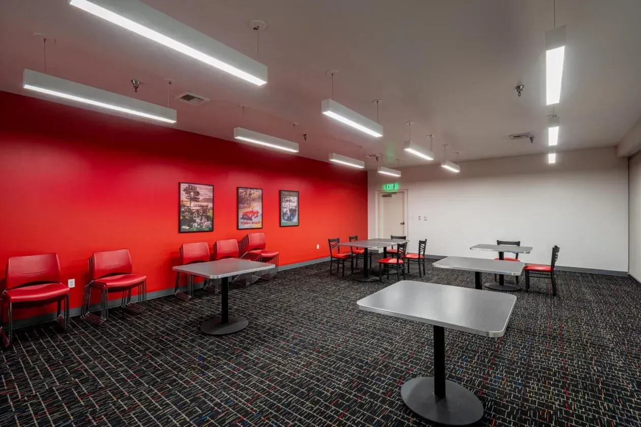 A room with tables and chairs and red walls.