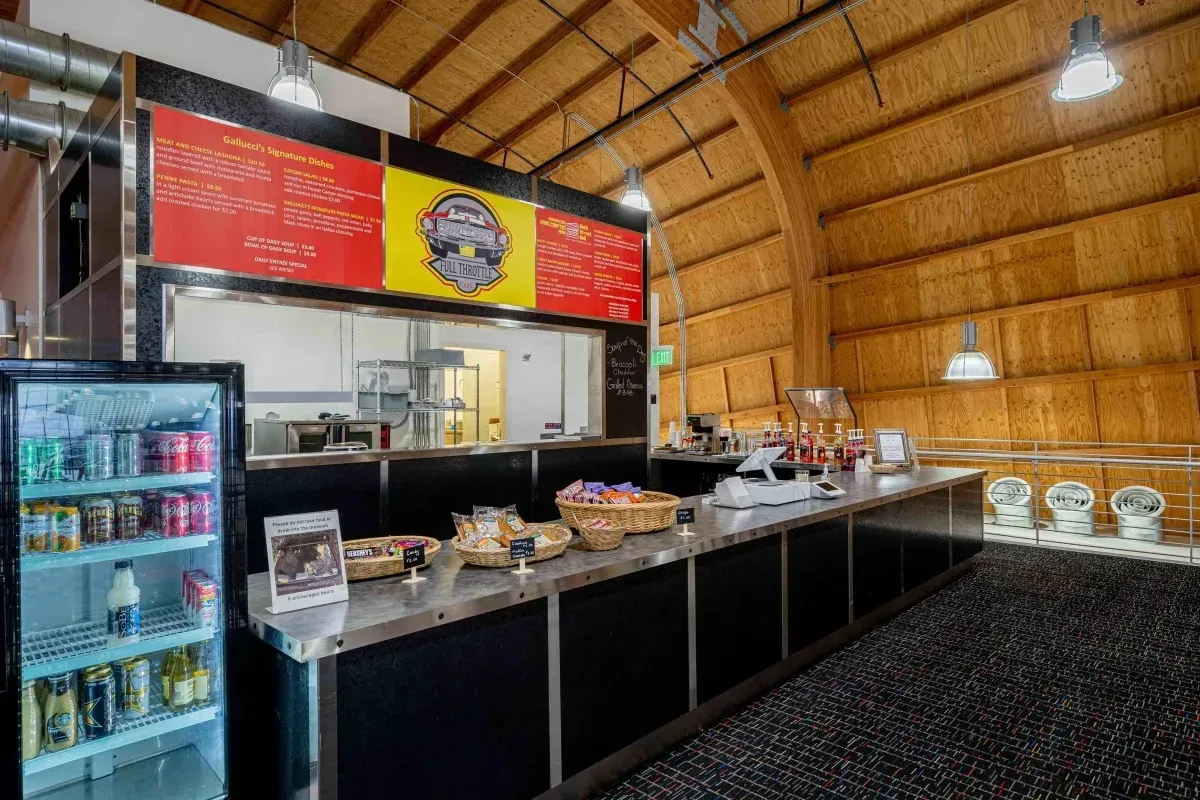 A restaurant with a long counter and a refrigerator.