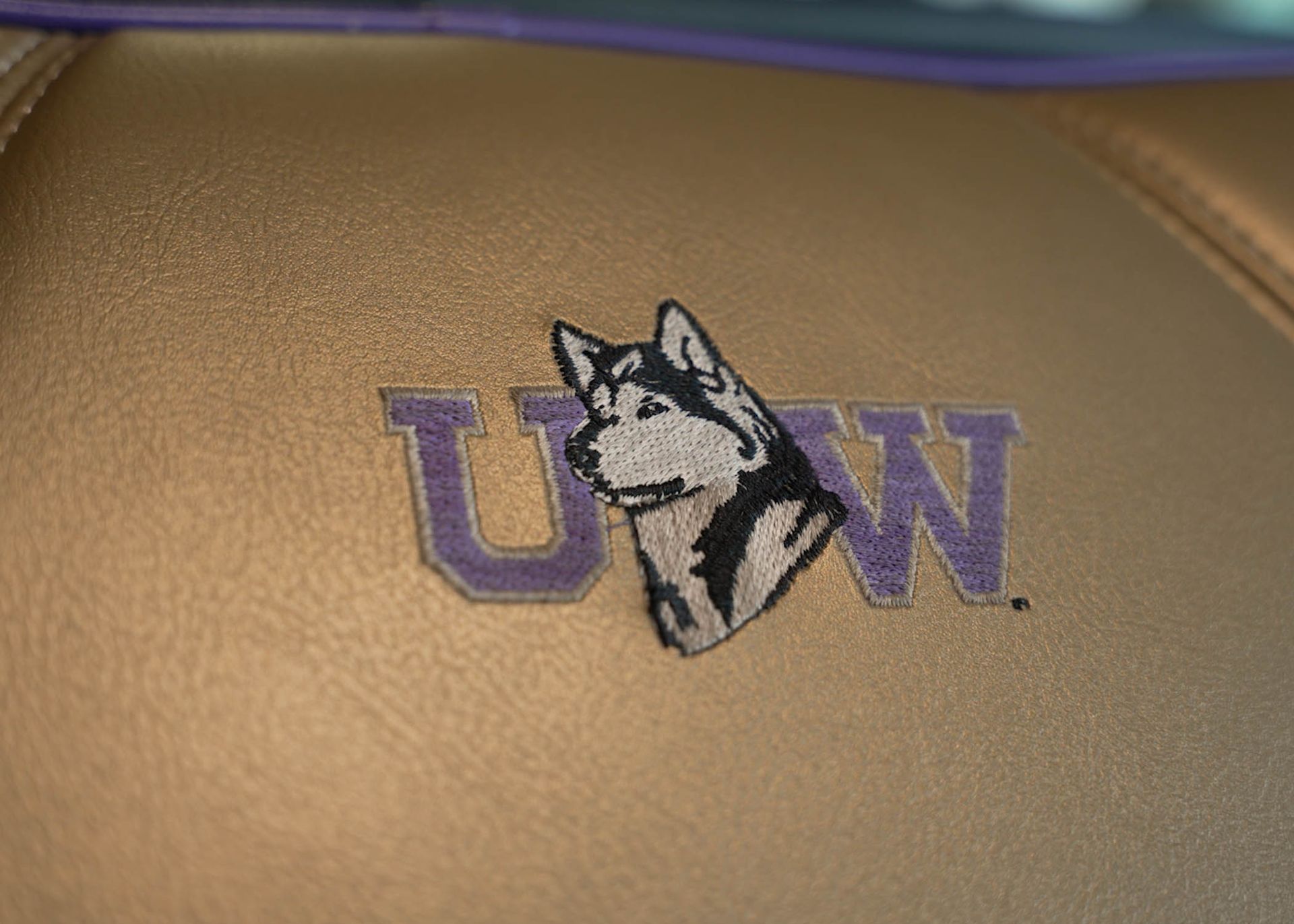 A husky logo is embroidered on a gold surface