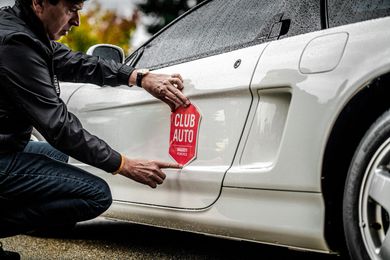 A row of porsche cars are parked in a parking lot