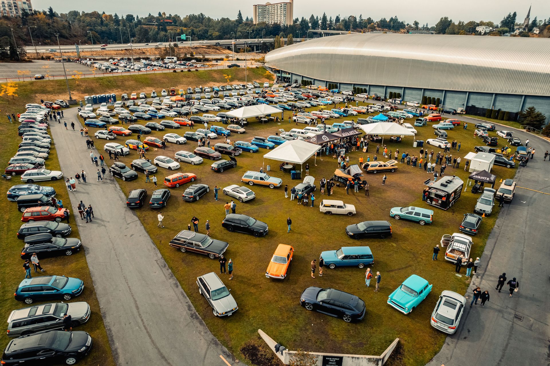 An aerial view of a parking lot filled with cars and people.