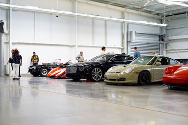 An old red car is parked in a museum.