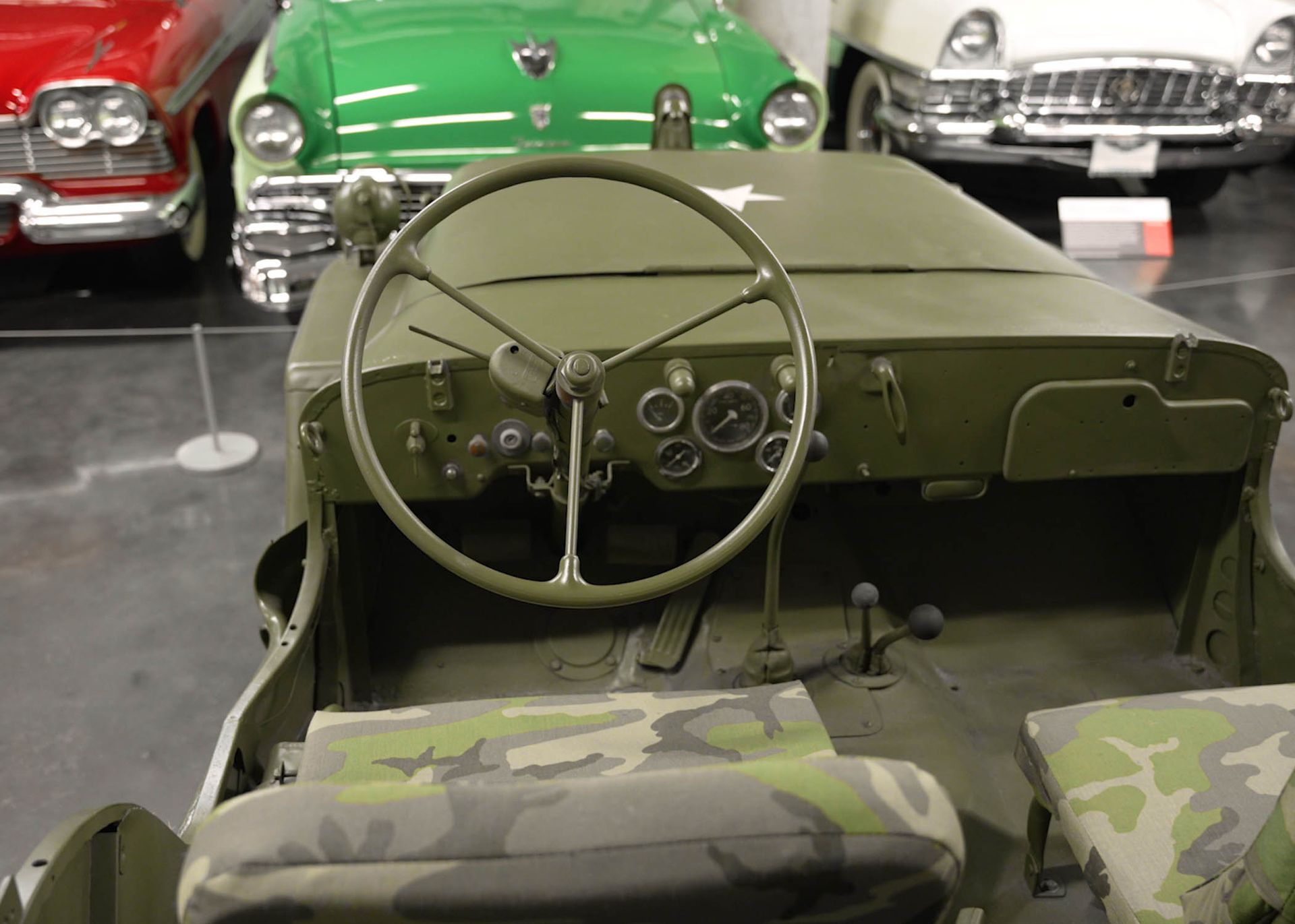 A green jeep with a camouflage seat and steering wheel