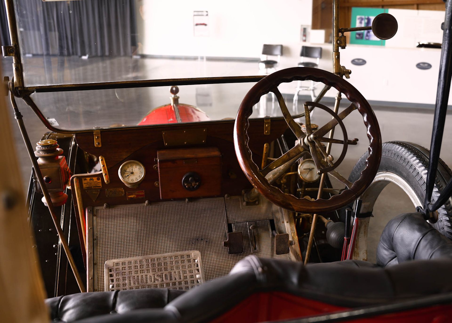 The inside of an old car with a wooden steering wheel