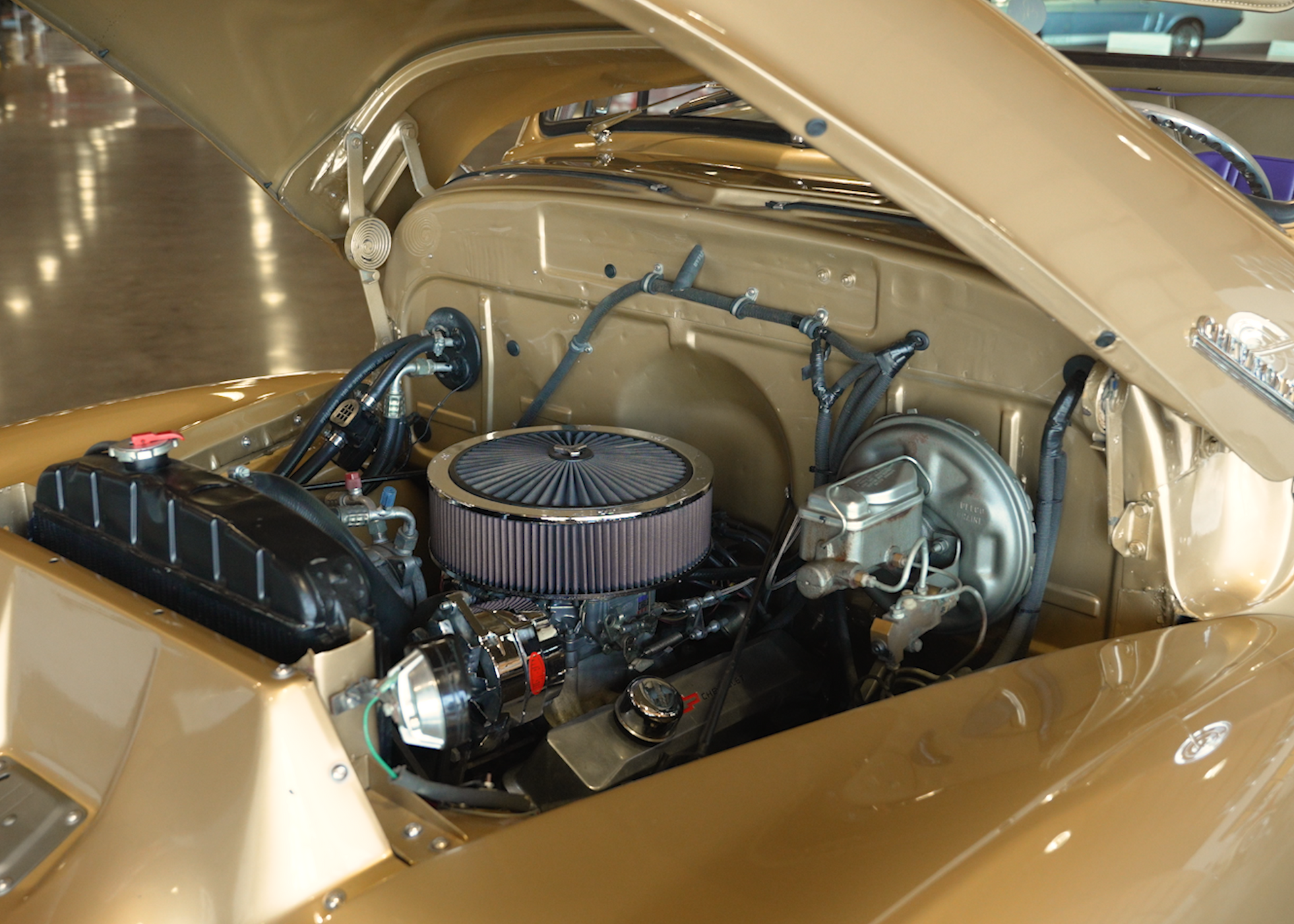 A close up of a car engine with the hood open