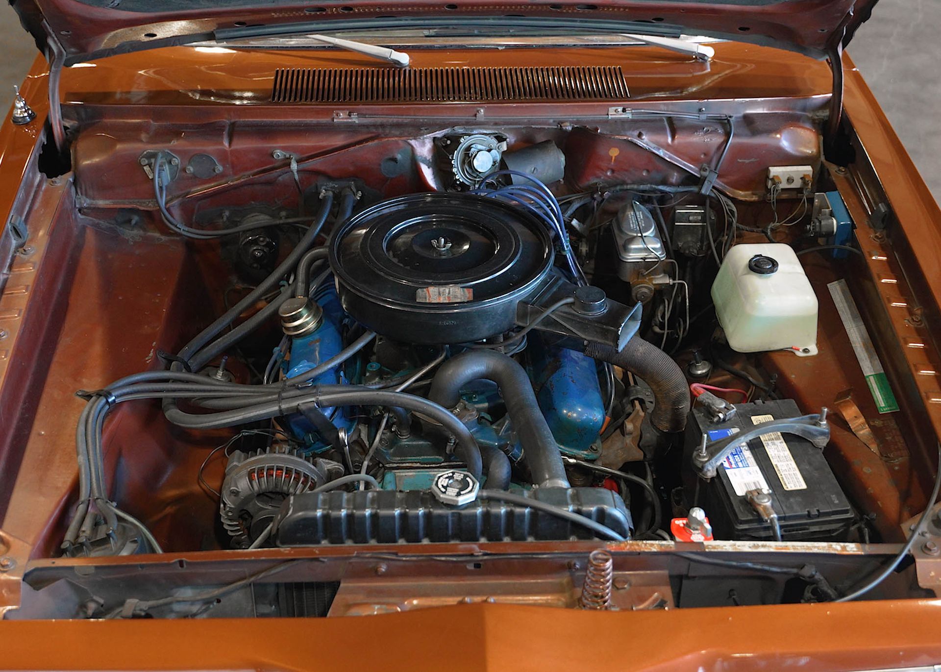 A close up of a car engine with the hood open