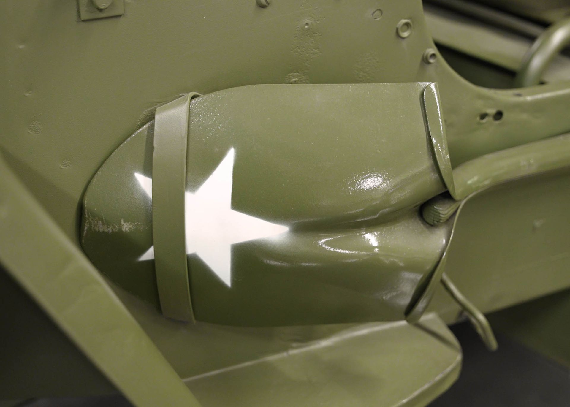 A green military vehicle with a white star on the side.