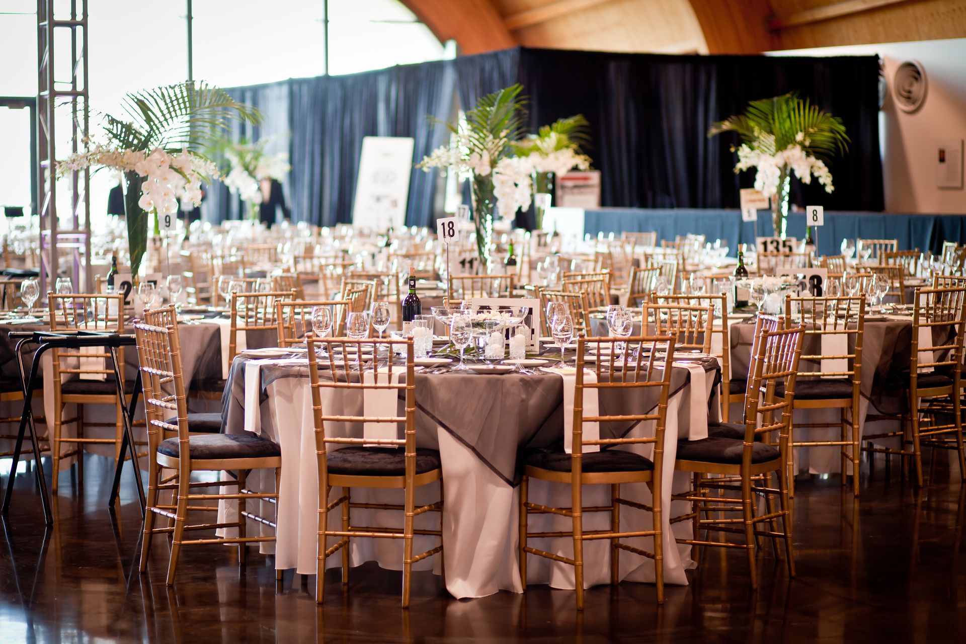 A large room with tables and chairs set up for a wedding reception.