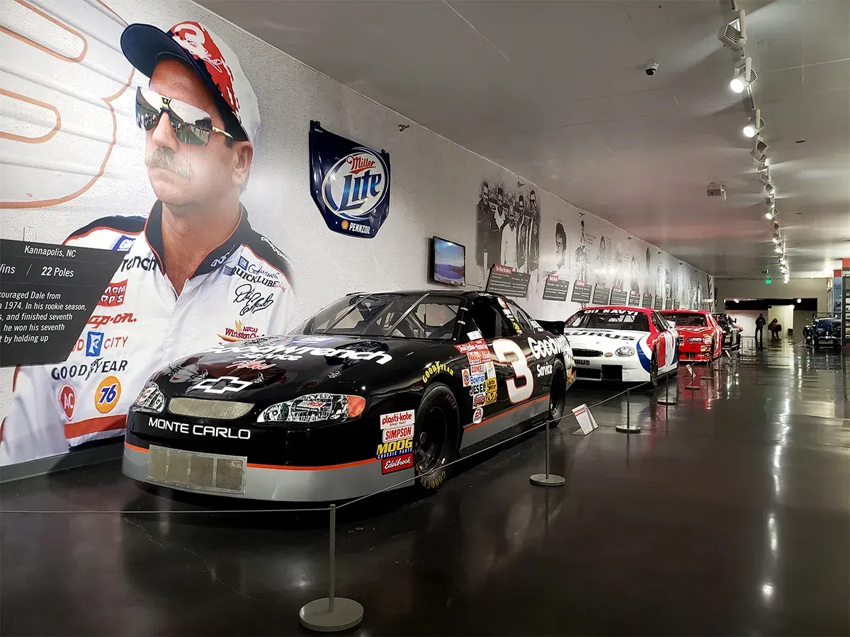 A row of race cars are on display in a museum
