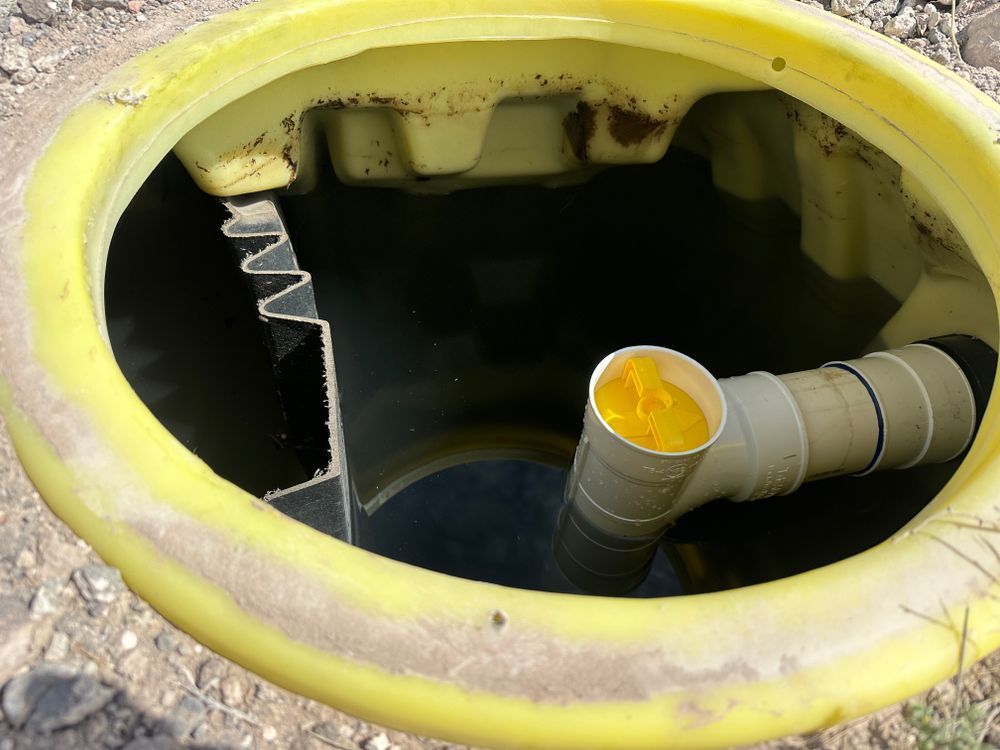 Yellow septic tank interior with a pipe, a divider, and liquid visible.