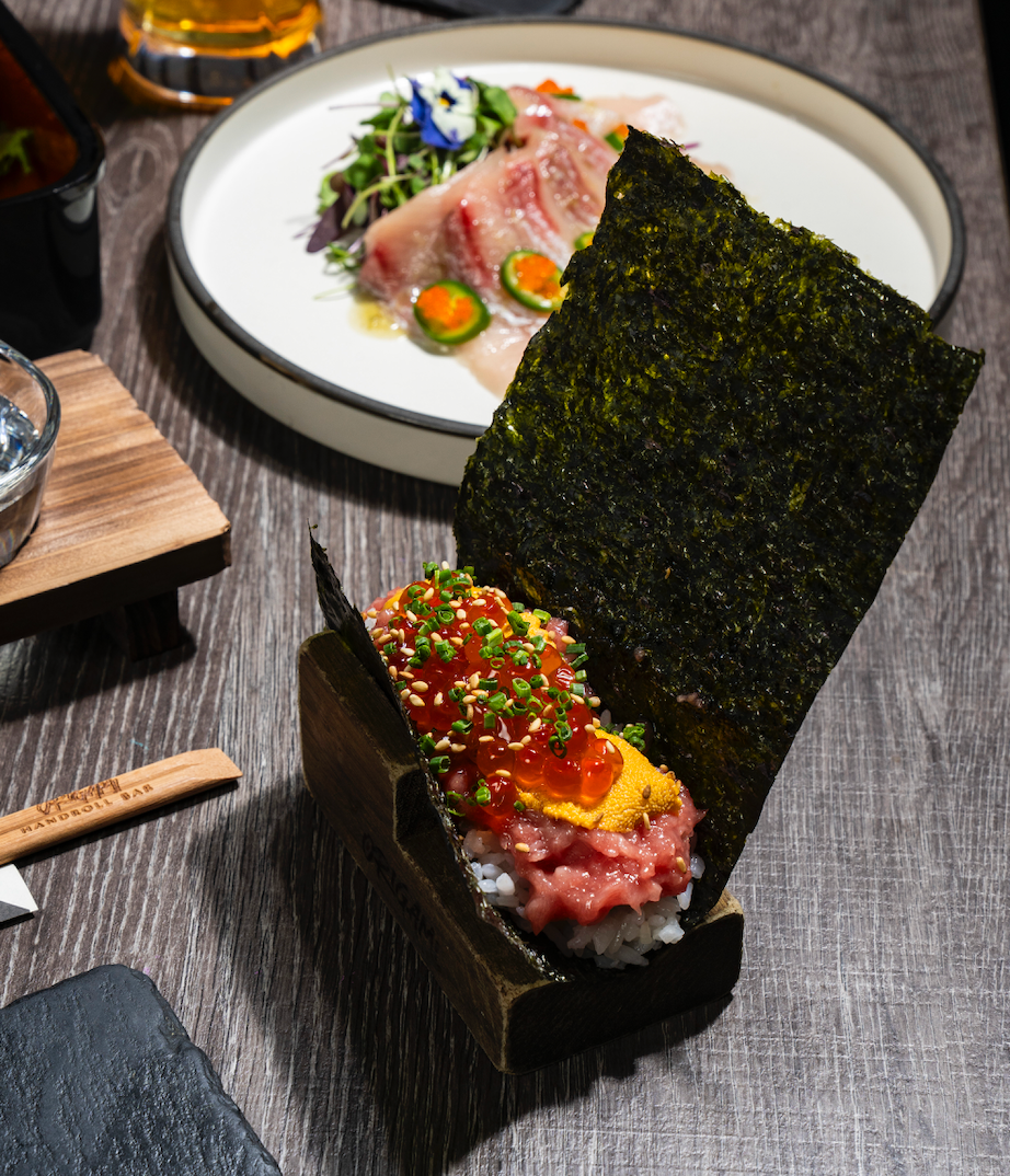 a box of sushi with a red label that says handroll bar
