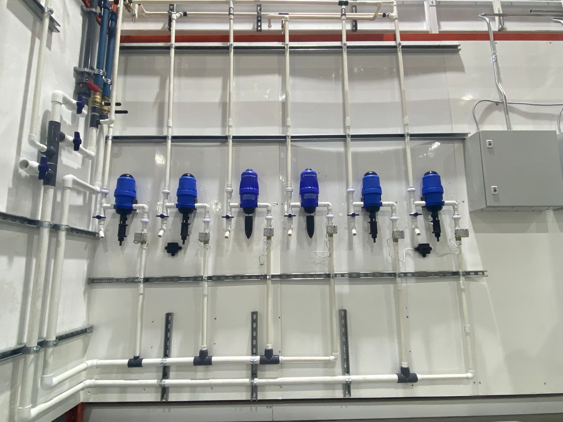 Un tas de tuyaux sont accrochés au mur d’une pièce.